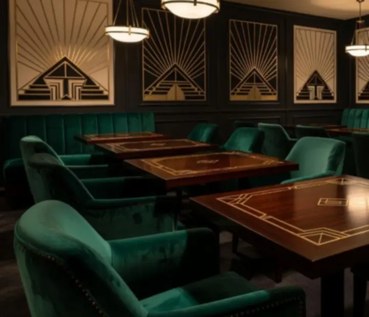 Wnętrze restauracji w stylu Art Deco z ciemnym drewnem i aksamitnymi fotelami